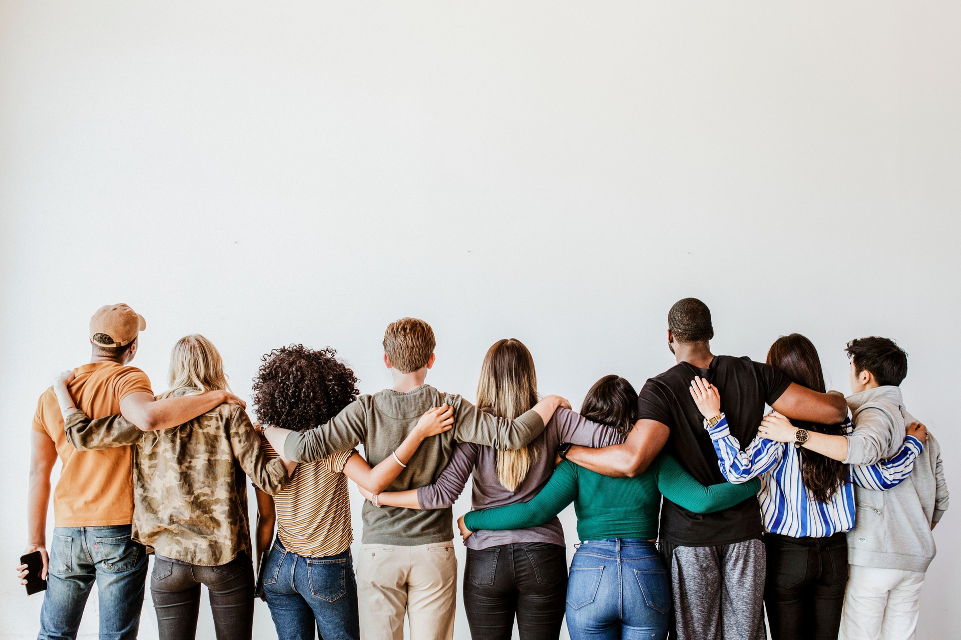 Vista posteriore di persone diverse che si abbracciano